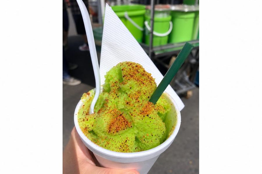 Nieve de limón con chile en polvo servida en un vaso en un mercado
